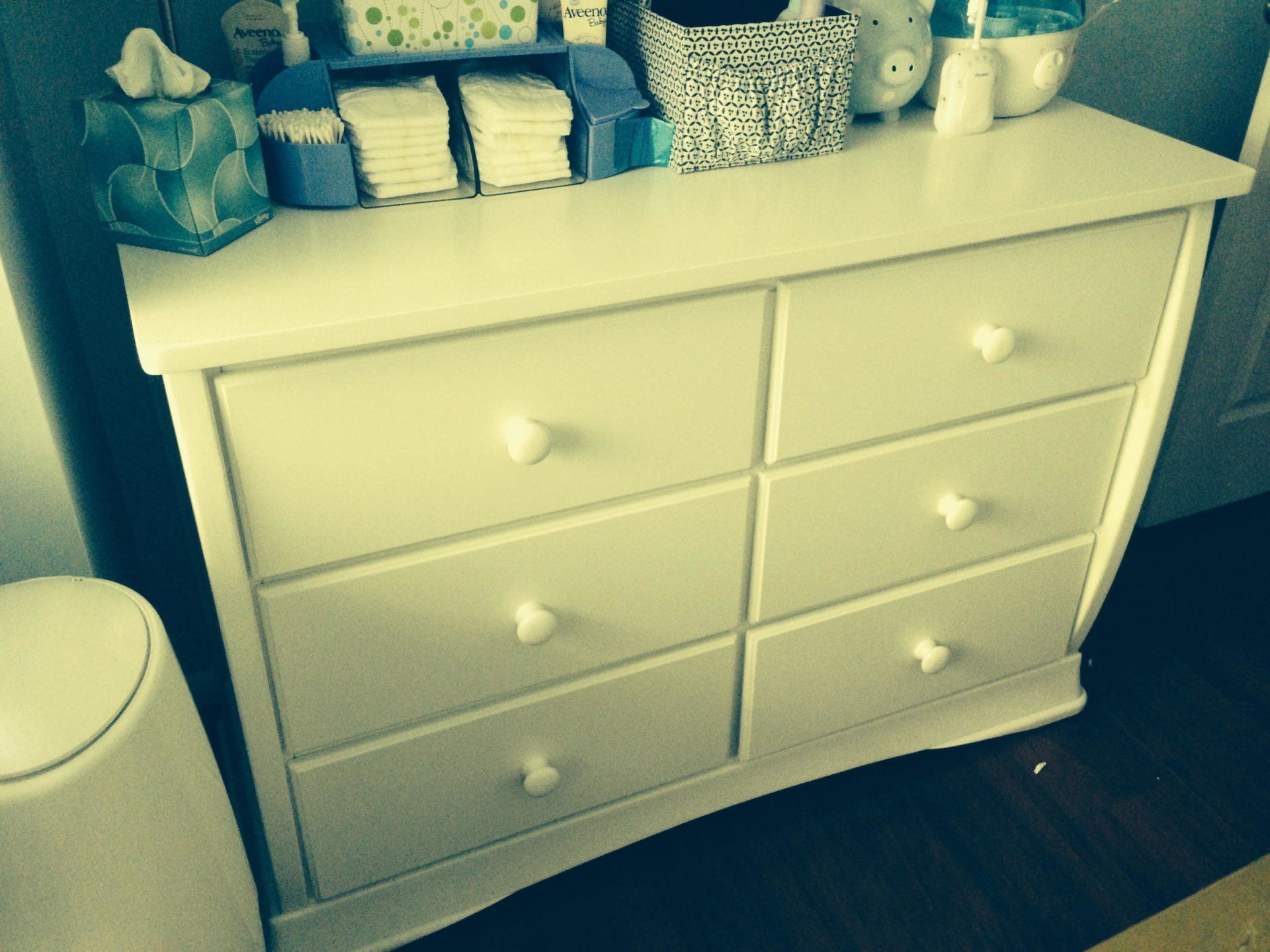 A white dresser with diapers on top of it