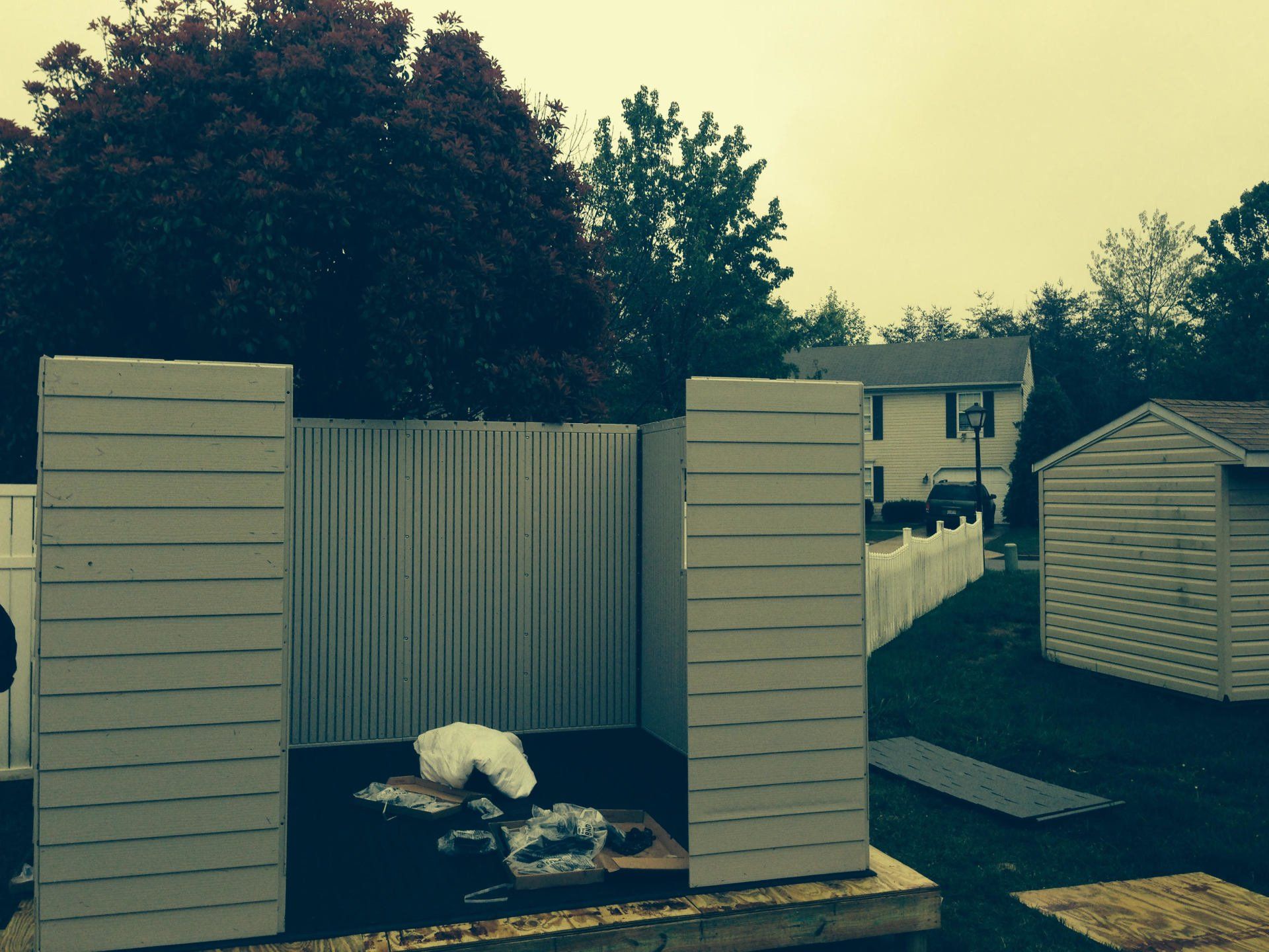 A fence is being built in the backyard of a house