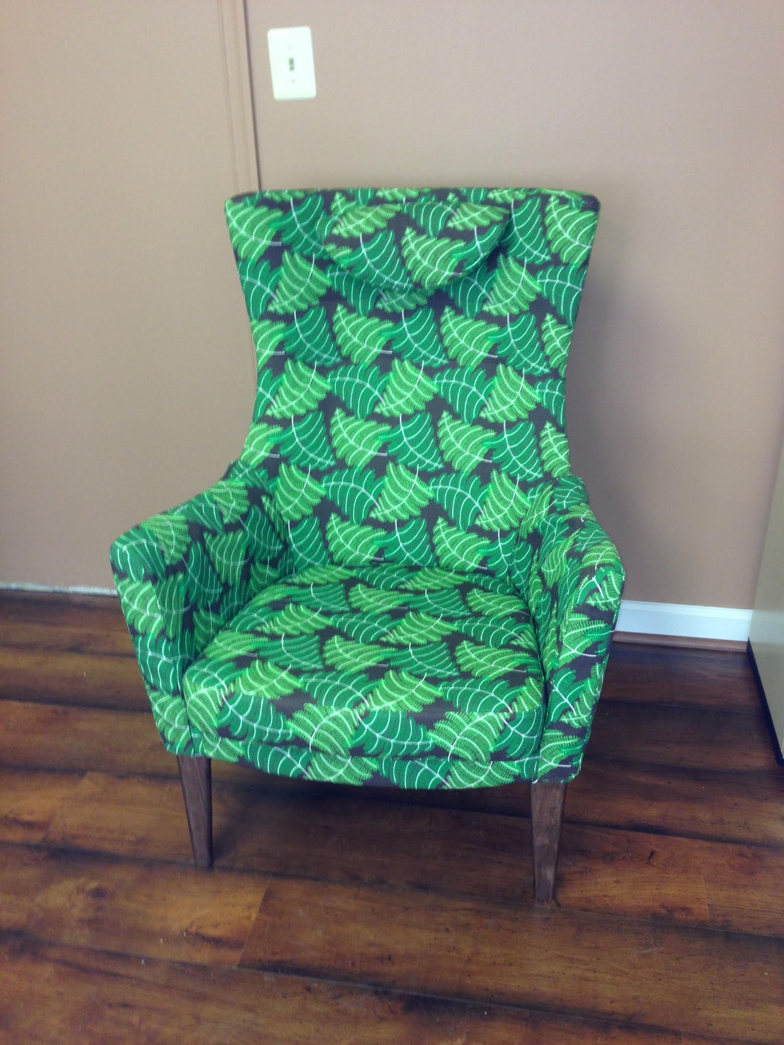 A green chair is sitting on a wooden floor