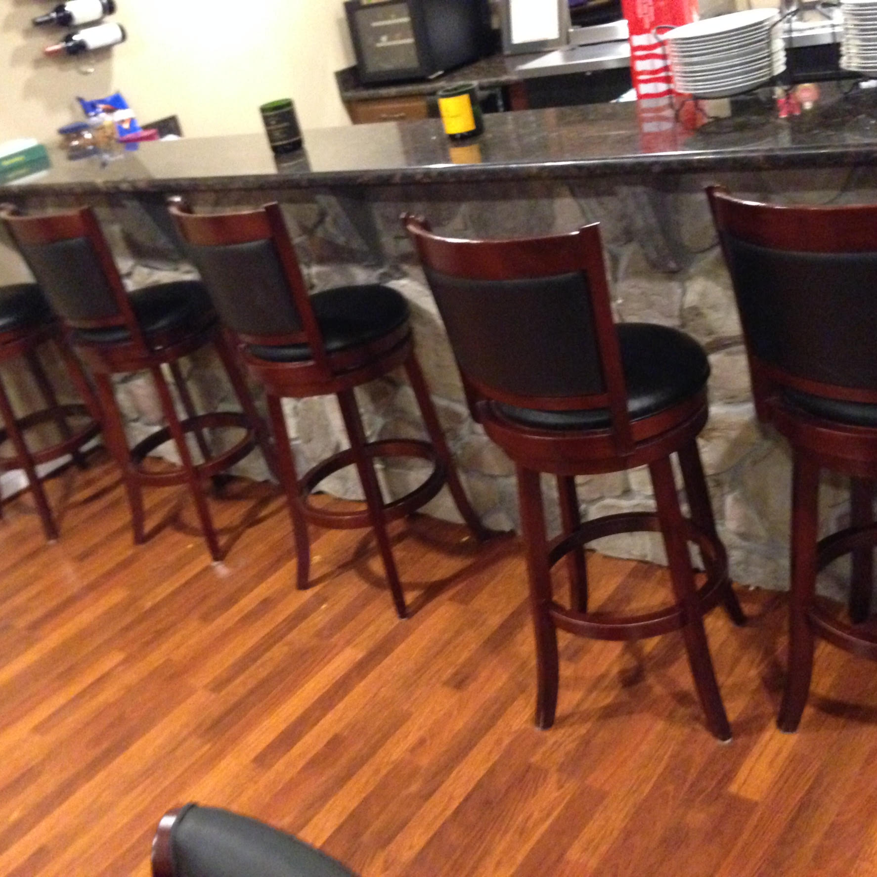 A row of bar stools are lined up in front of a counter