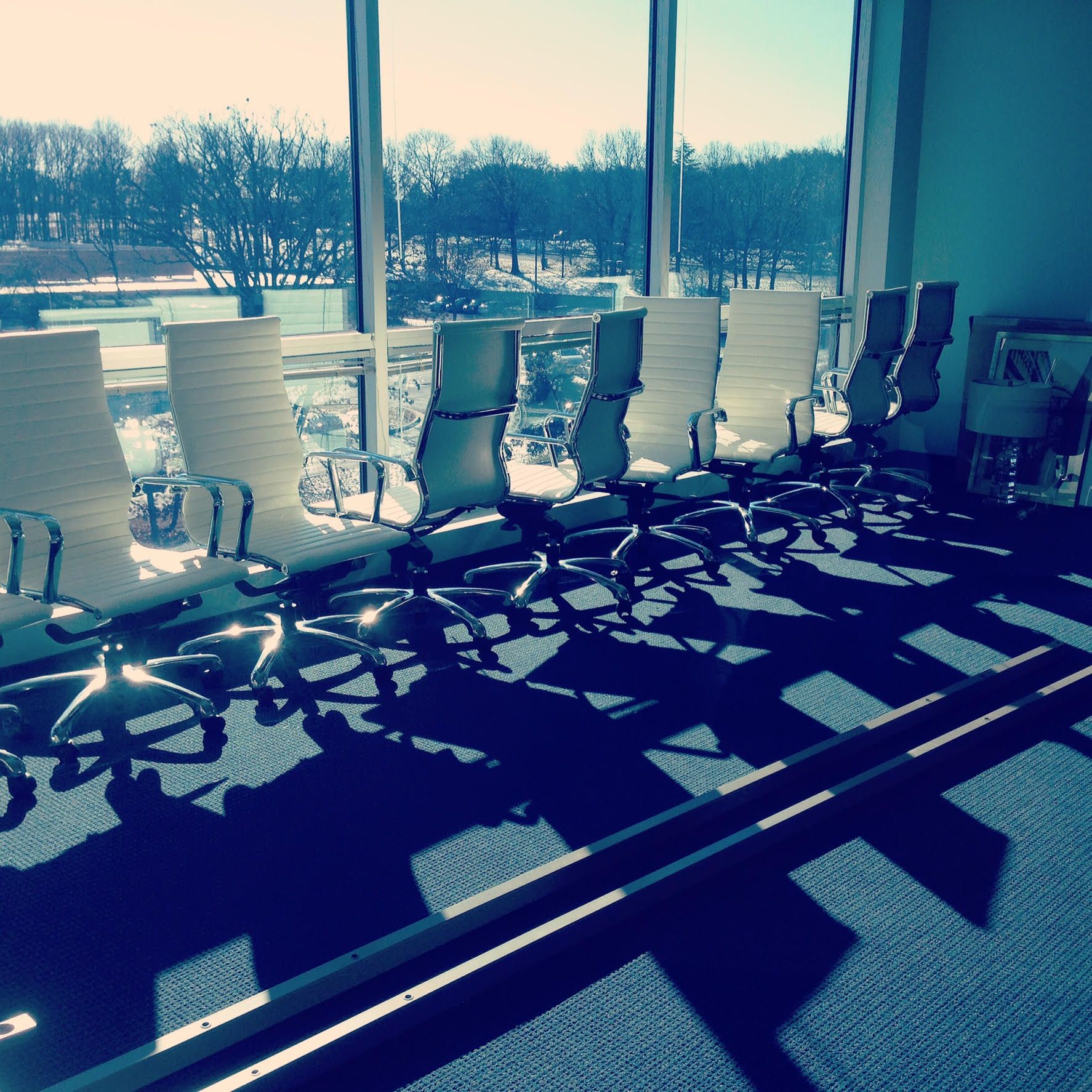 A conference room with a lot of chairs and a large window