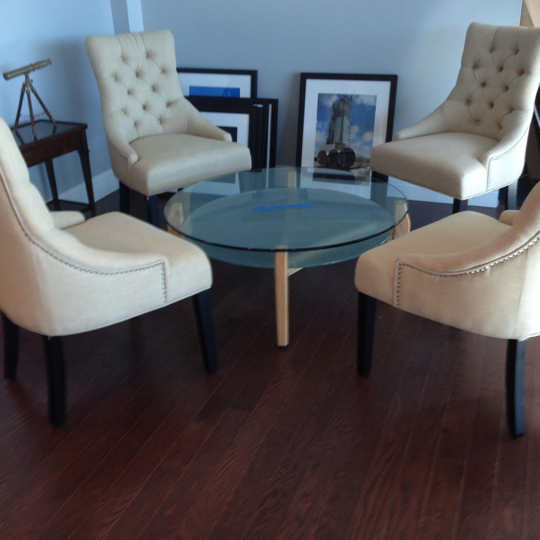 Four chairs are sitting around a glass coffee table