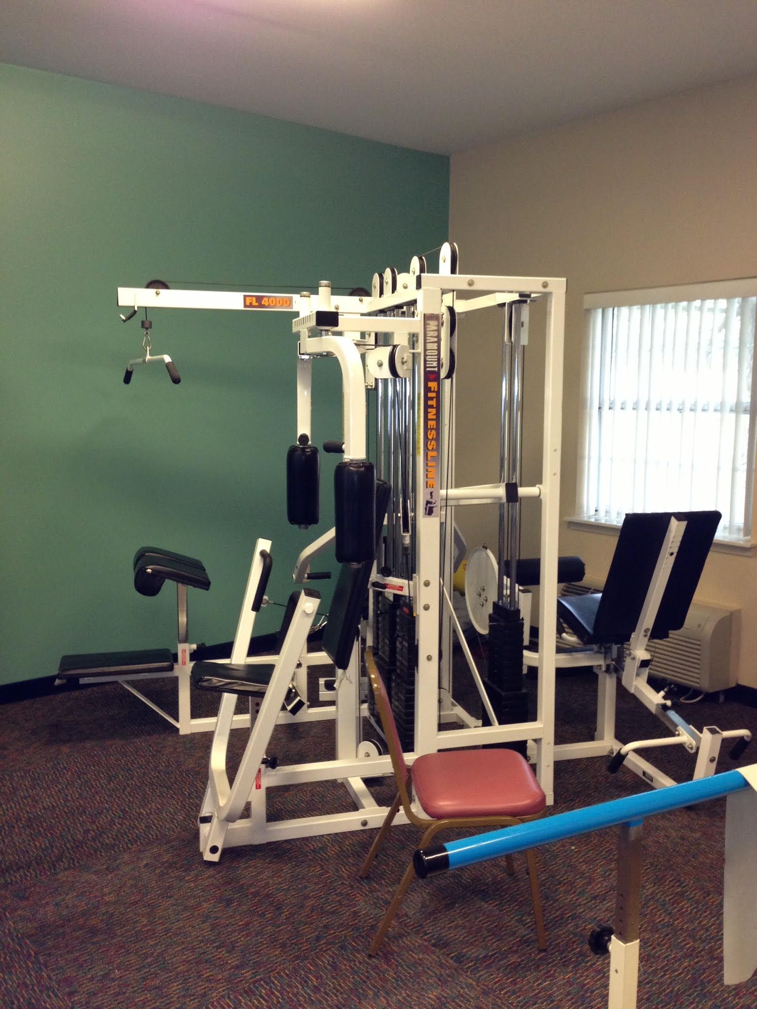 A gym with a lot of equipment and a window