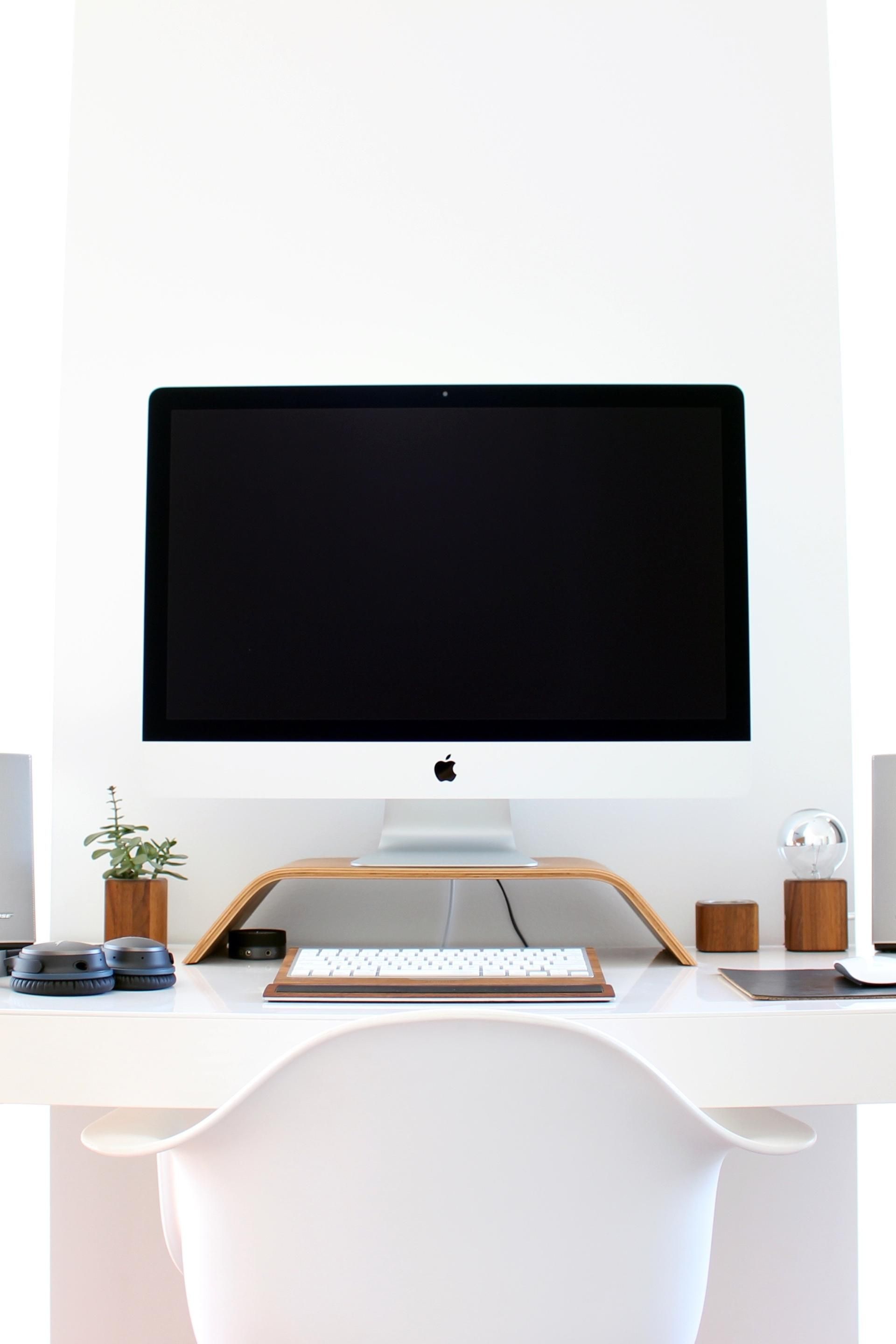 A computer monitor is sitting on top of a white desk.