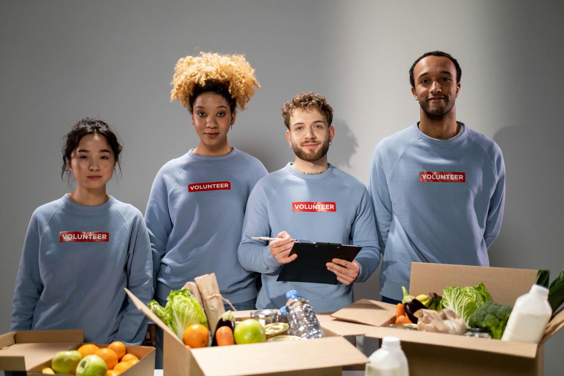 五個人站在幾箱食品雜貨後面，手裡拿著平板電腦，象徵聯豐夥伴努力打造友善畜產的環境。