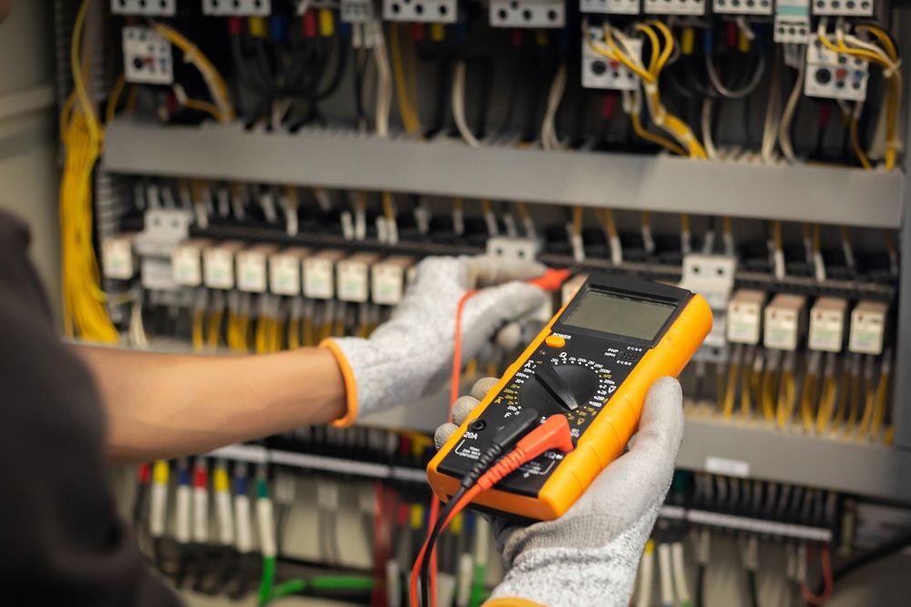 A person is using a multimeter to test a circuit board.