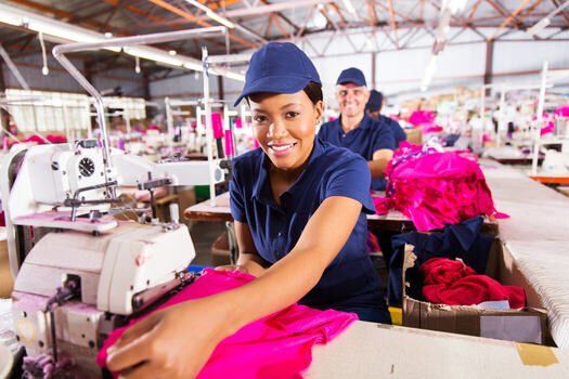 A young man sewing at a textile factory in Toronto.