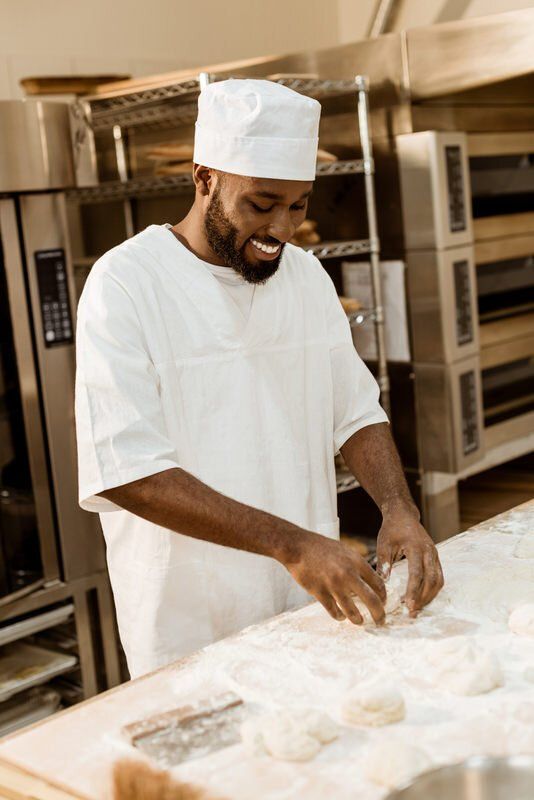 Smiling man at his temporary and flexible job at a bakery in the Toronto area.