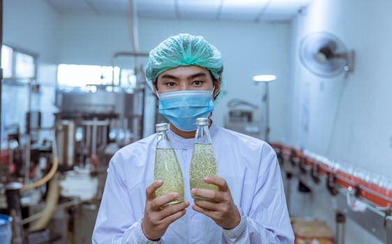 Man holding bottles in a bottle factory in Brampton, Ontario.
