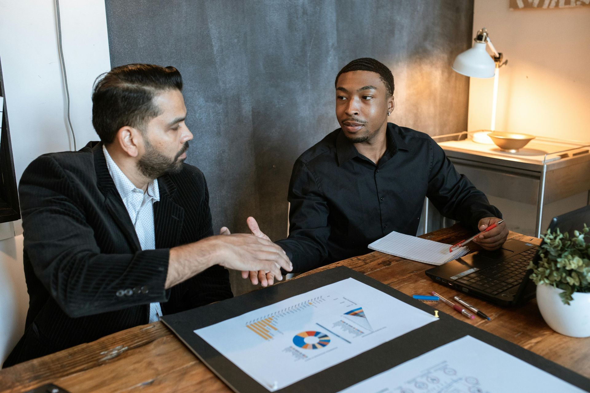 A warehouse owner shaking hands with an employee that he hired through a warehouse staffing agency