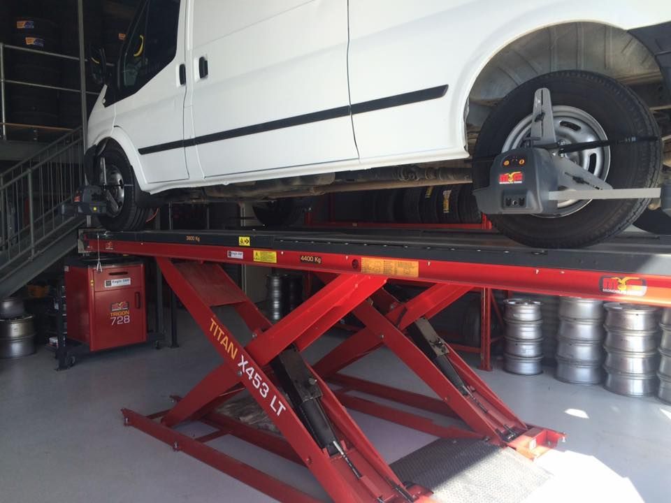 White Van On A Lift For Wheel Alignment — Tyre Master Albury In East Albury, NSW