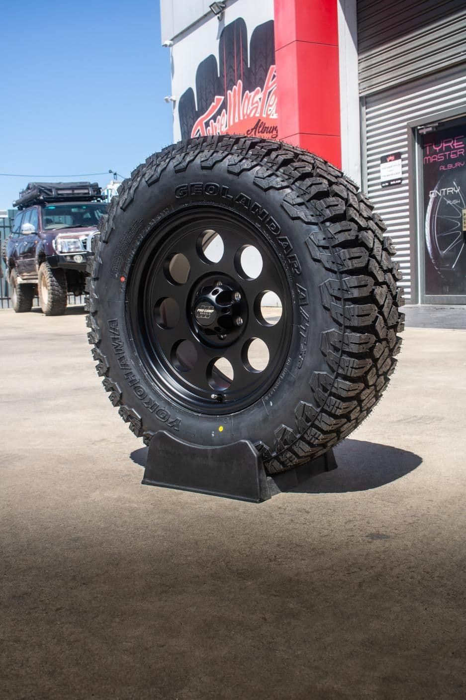 A Tire Is Sitting On A Tire Stand In Front Of A Building — Tyre Master Albury In Wodonga, VIC