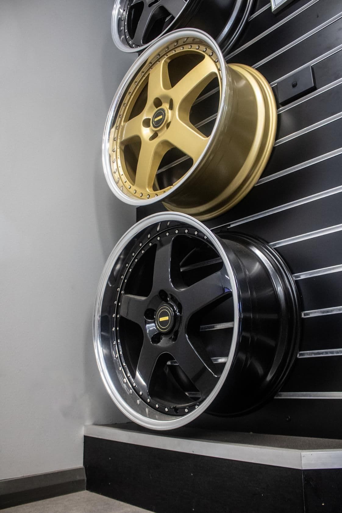 Three Different Colored Wheels Are Hanging On A Wall — Tyre Master Albury In Wodonga, VIC