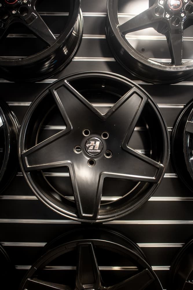 A Row Of Black Wheels Are Hanging On A Wall — Tyre Master Albury In Corowa, NSW