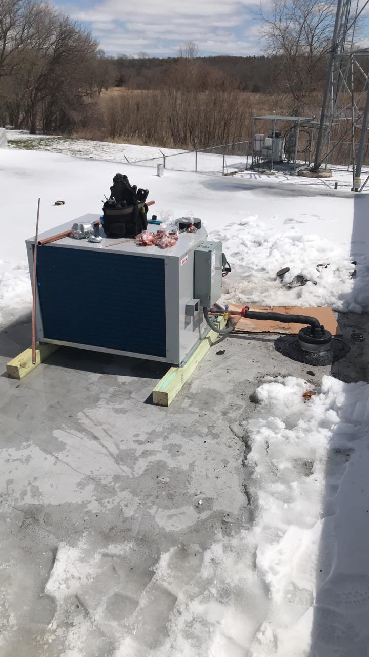 A large box is sitting on top of a snow covered ground.