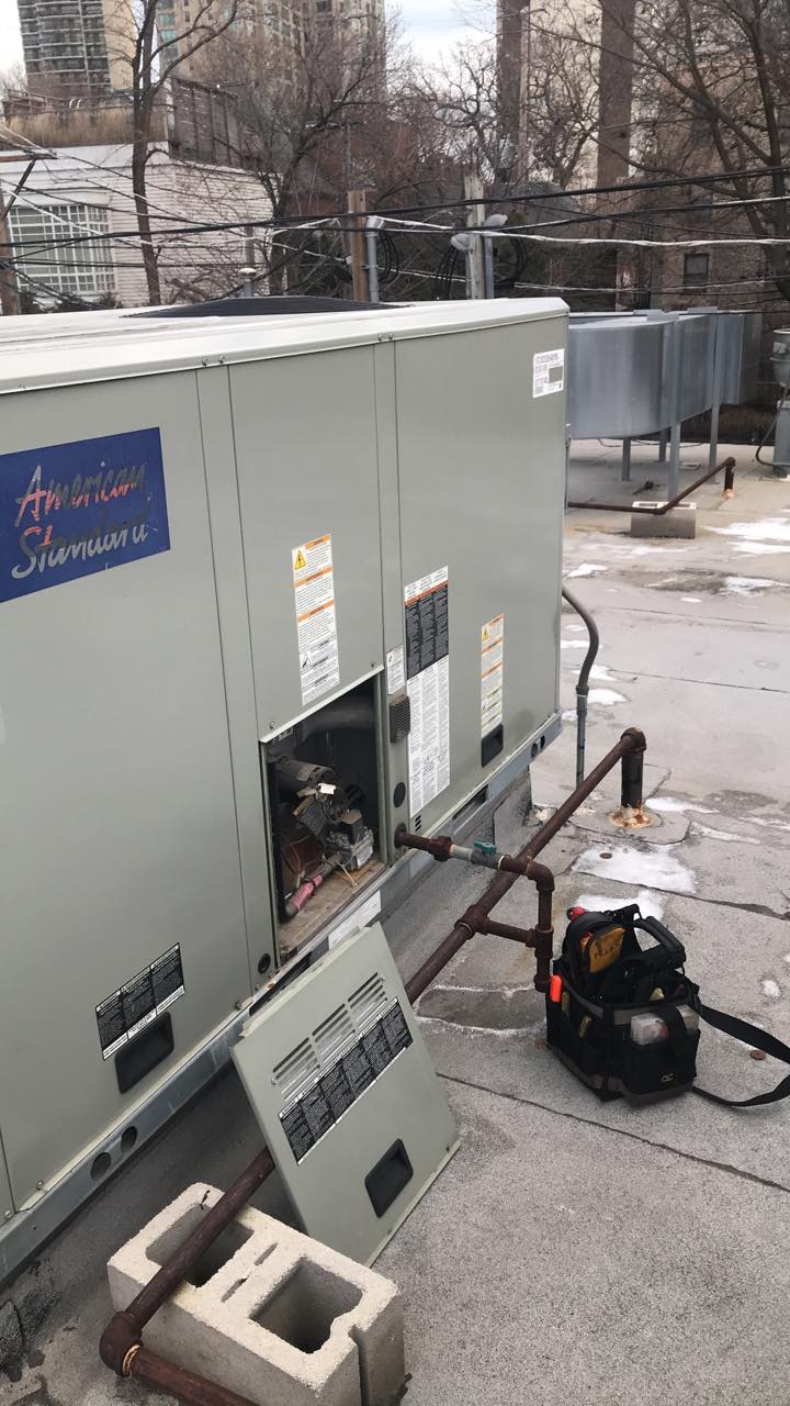 A couple of air conditioners are sitting on top of a roof.