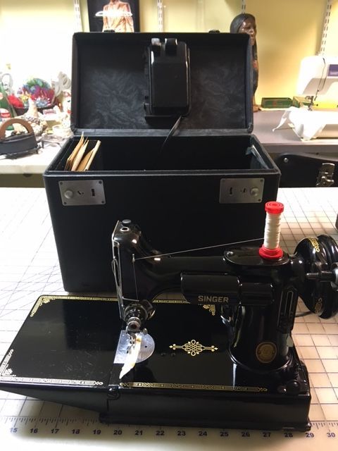 Black Singer sewing machine with open black carrying case.