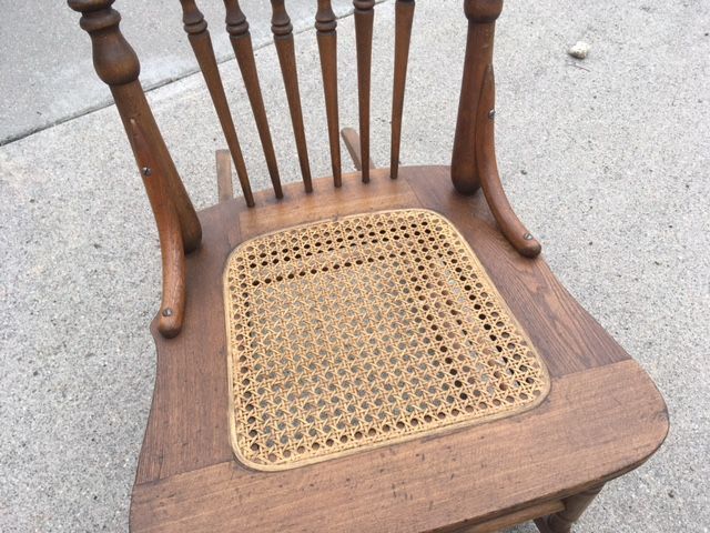 Wooden rocking chair with woven cane seat.