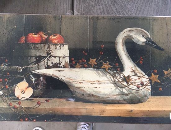 Rustic still life: wooden swan, bucket of apples, pear, garland with stars and berries.