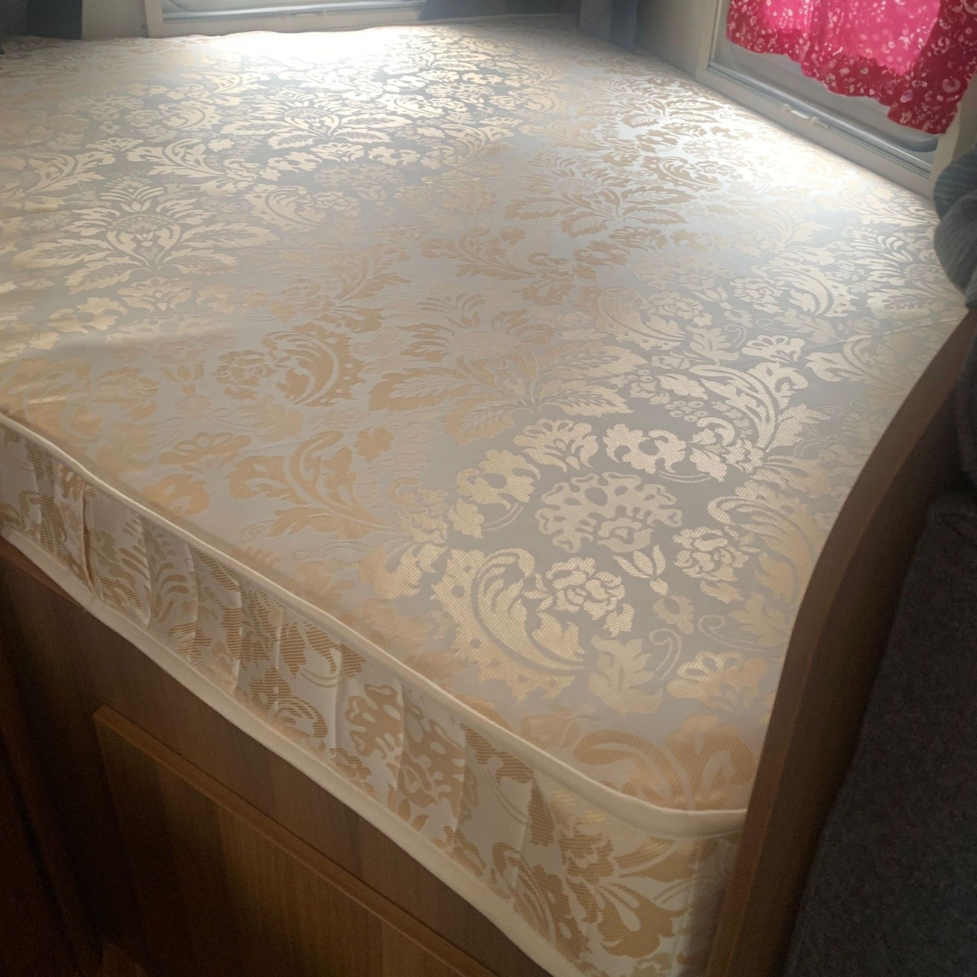 A golden covered mattress with a cut out in a caravan