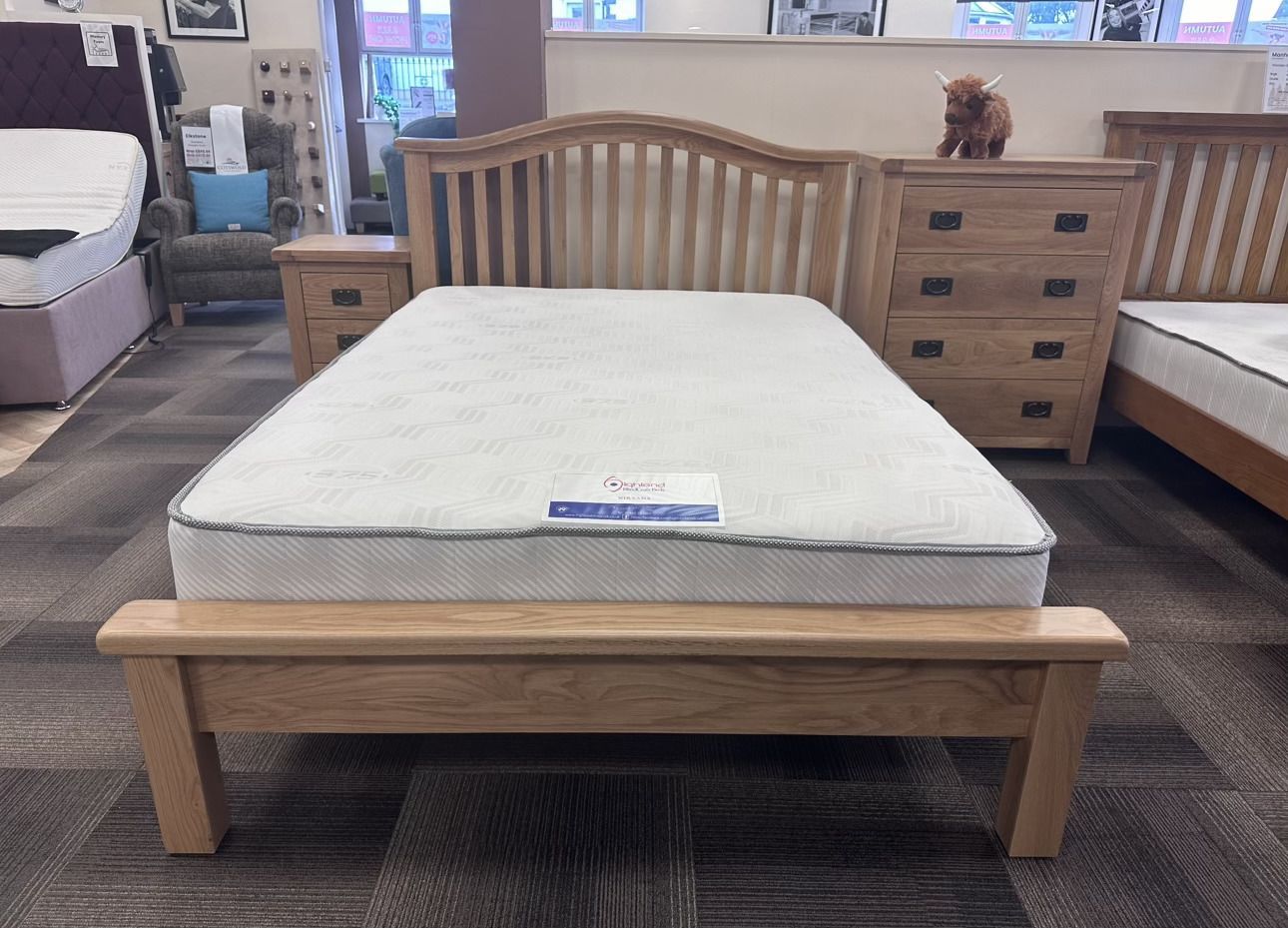A wooden bed frame with a striped headboard on a white background.