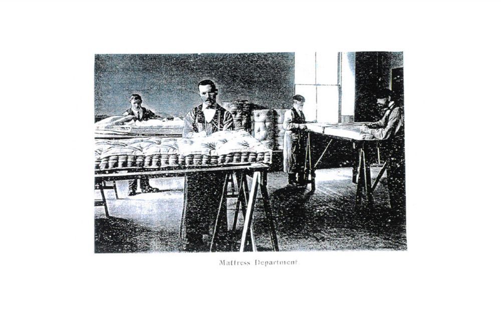 A black and white photo of people working in a factory.
