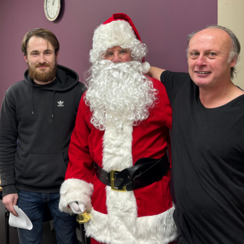 Santa stands with two male Highland BlindCraft employees