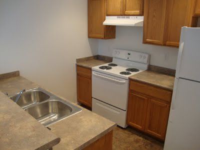 The kitchen includes a sink, stove, oven, granite countertops, and large refrigerator