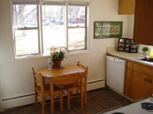 A kitchen with a small dining table and two chairs