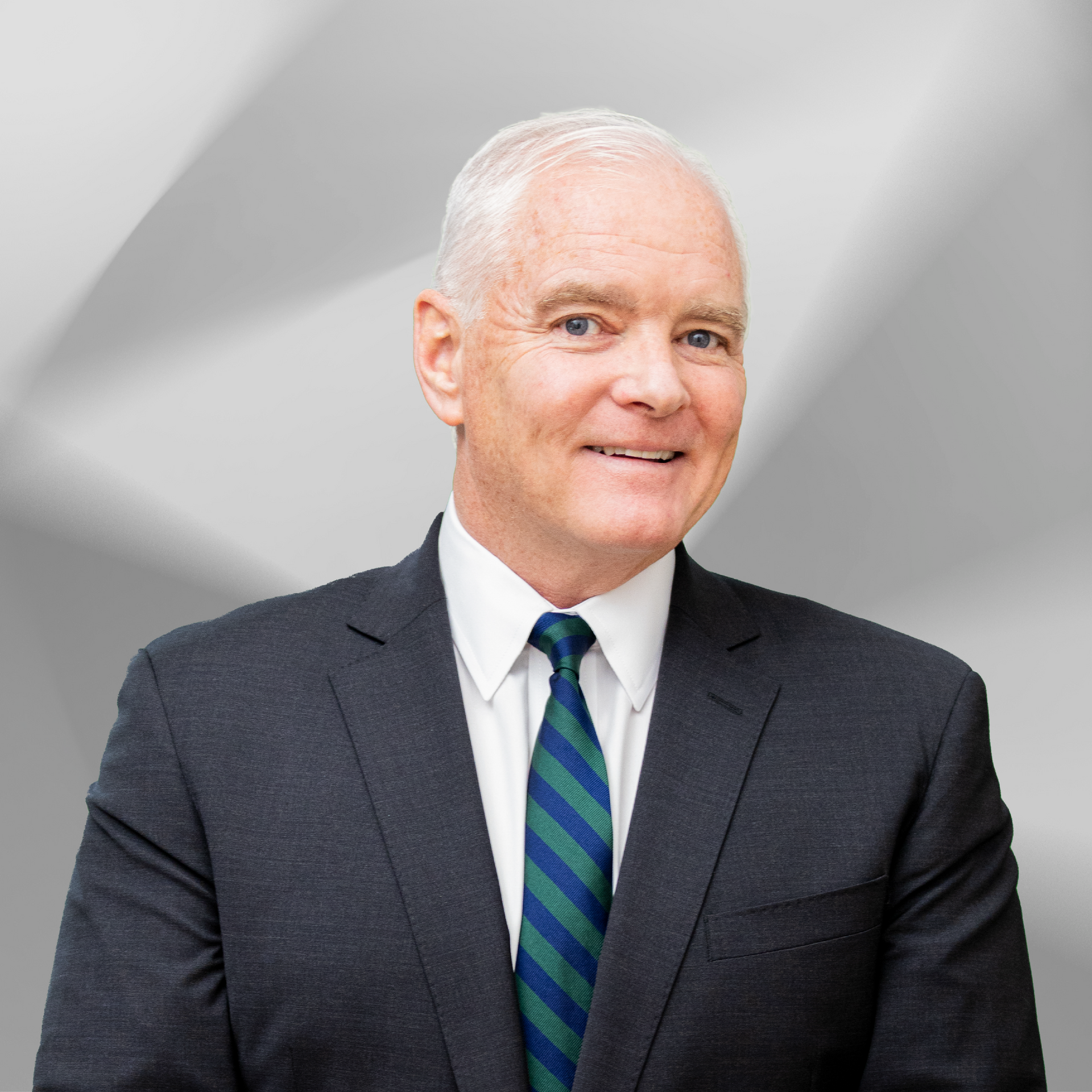 A man in a suit and tie is smiling for the camera.