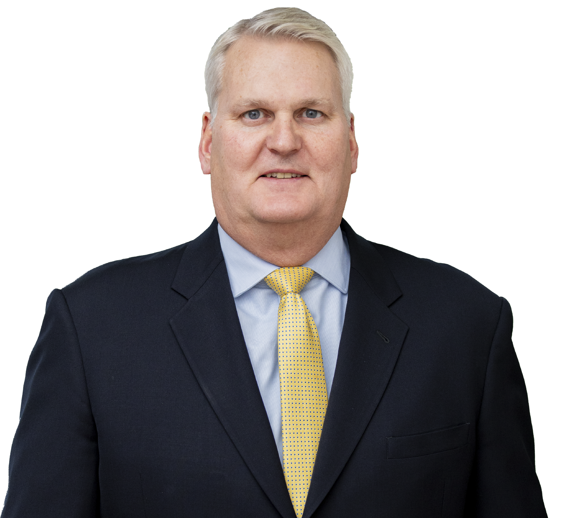 A man in a suit and tie stands in front of a white background