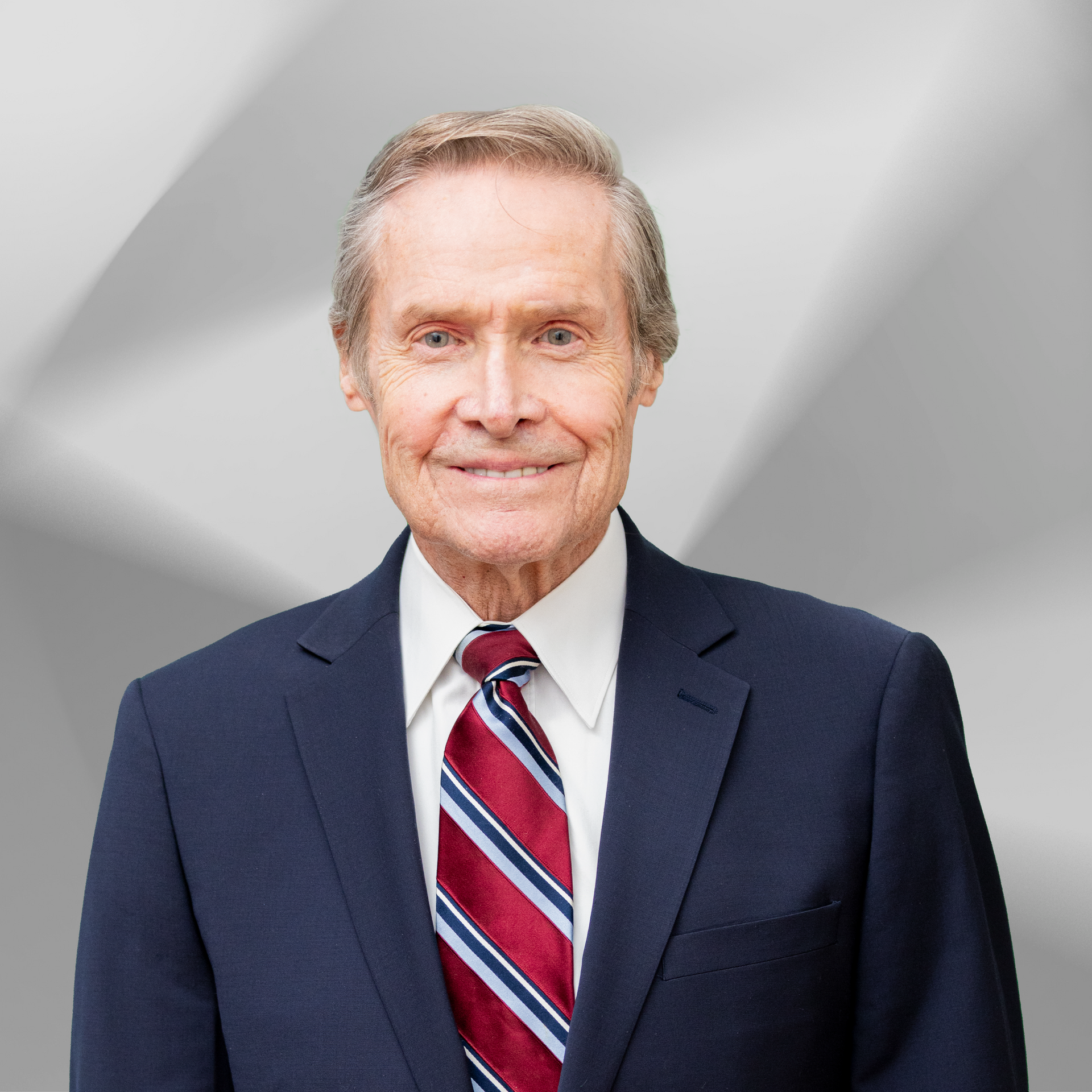 A man in a suit and tie is smiling for the camera