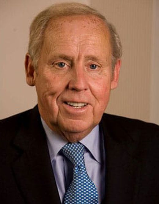 A man in a suit and tie is smiling for the camera.