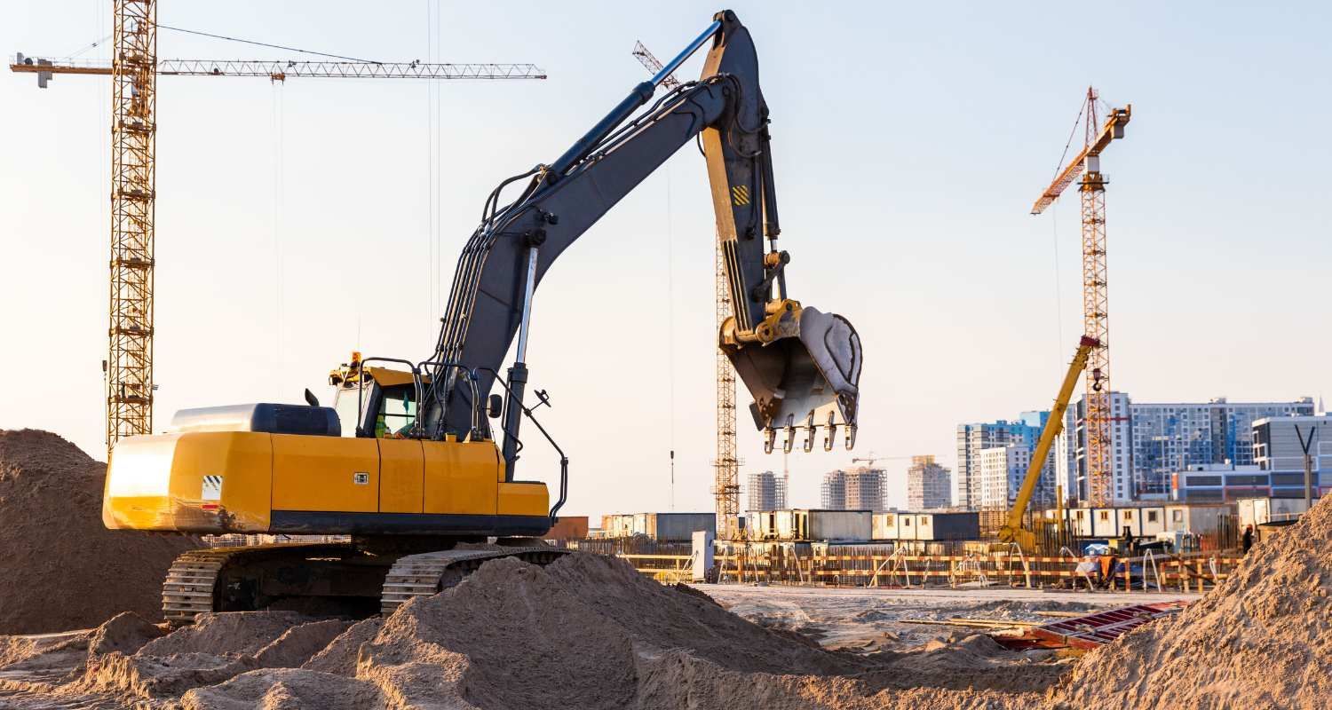 A yellow excavator is digging a hole at a construction site.
