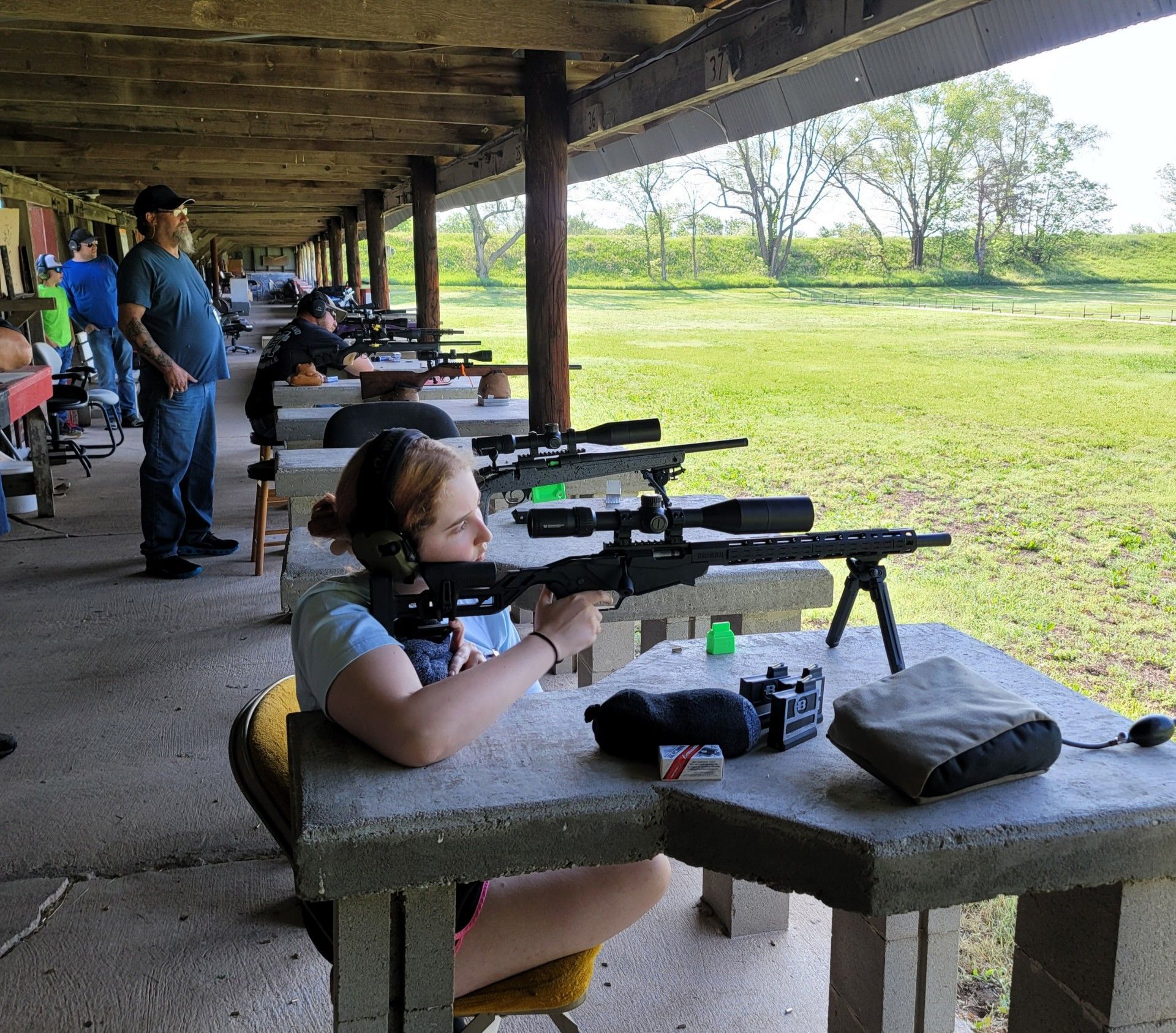 young woman taking aim holding a rifle at gun range