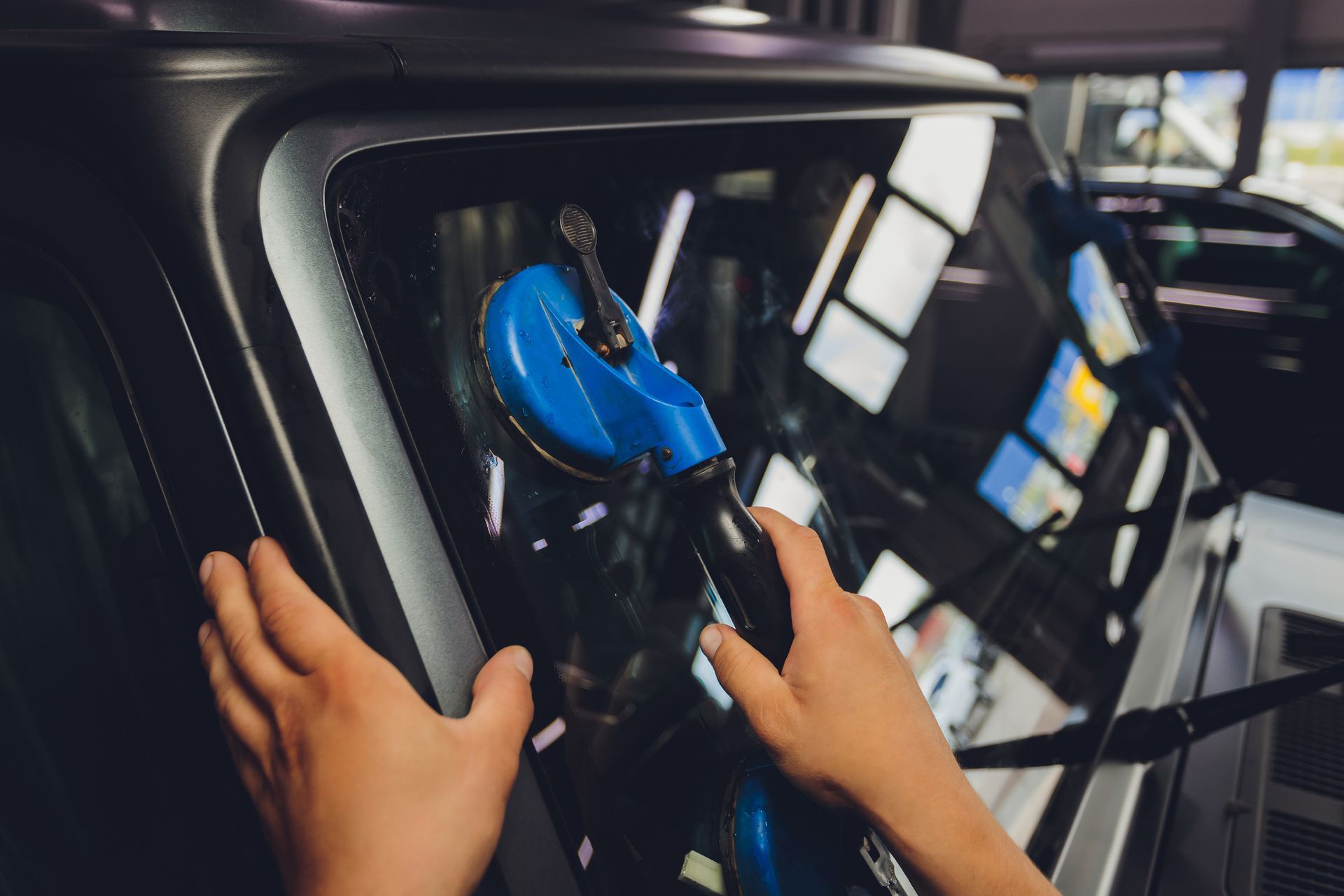 A person is installing a windshield on a car.