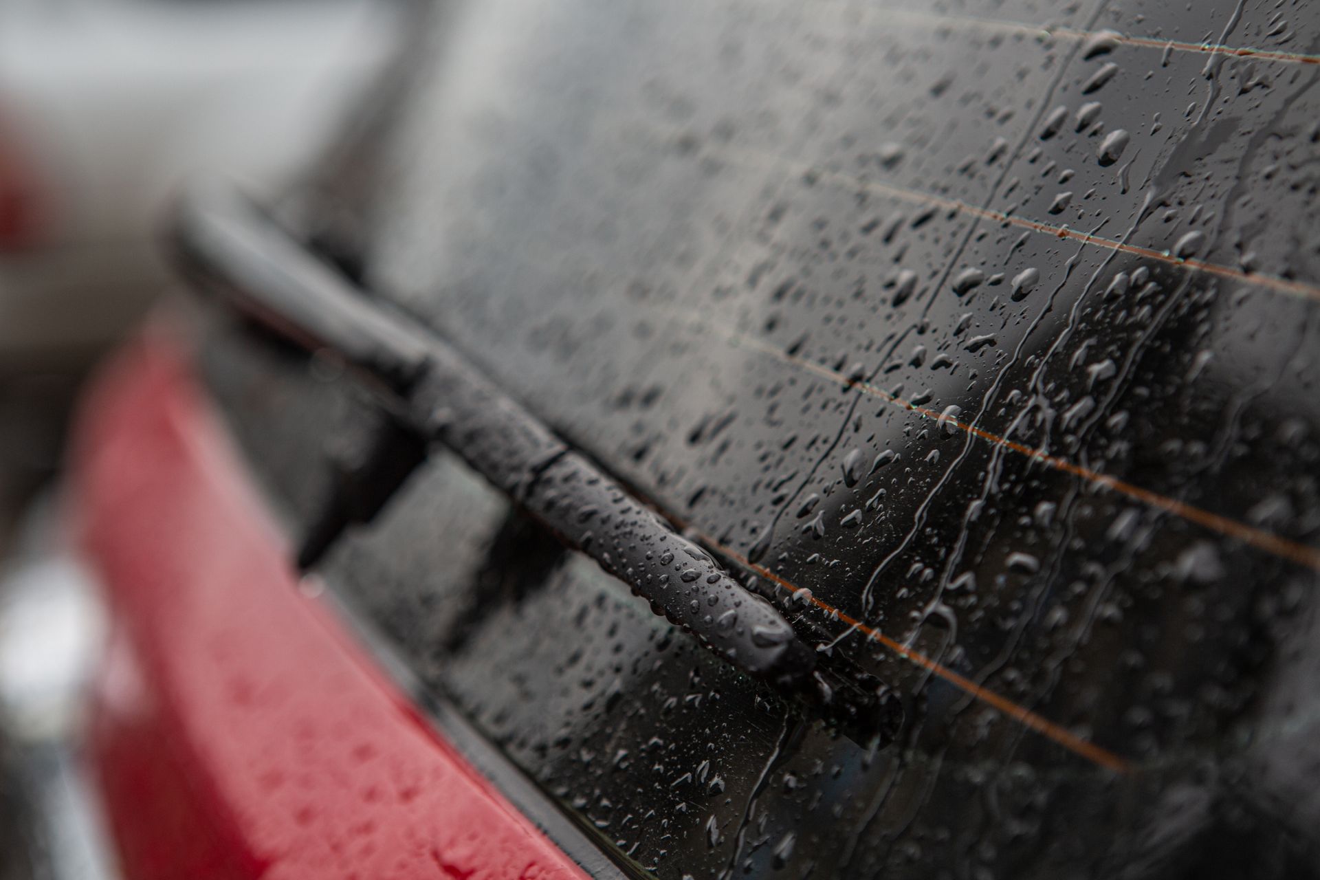 A close up of a car windshield with rain drops on it.