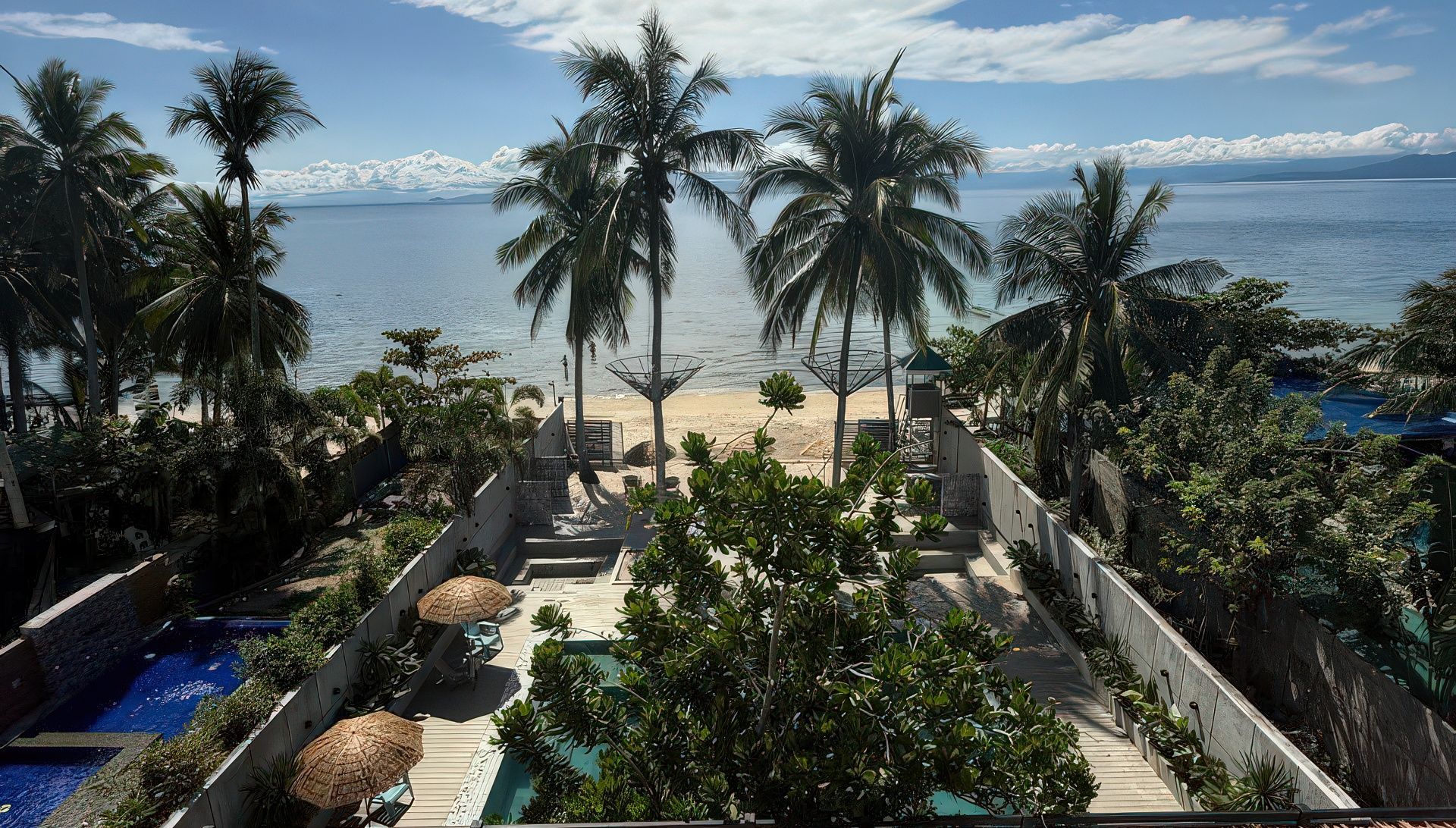 An aerial view of a tropical resort with palm trees and swimming pools