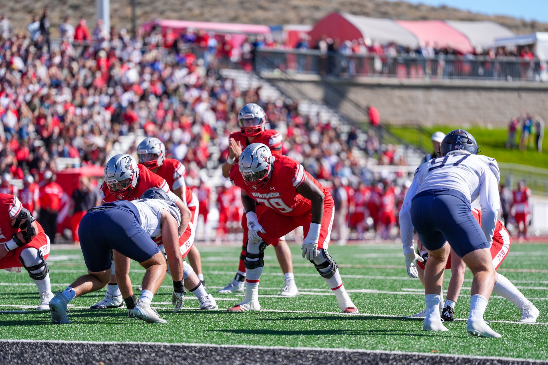 Football players in red and white uniforms in a stadium.