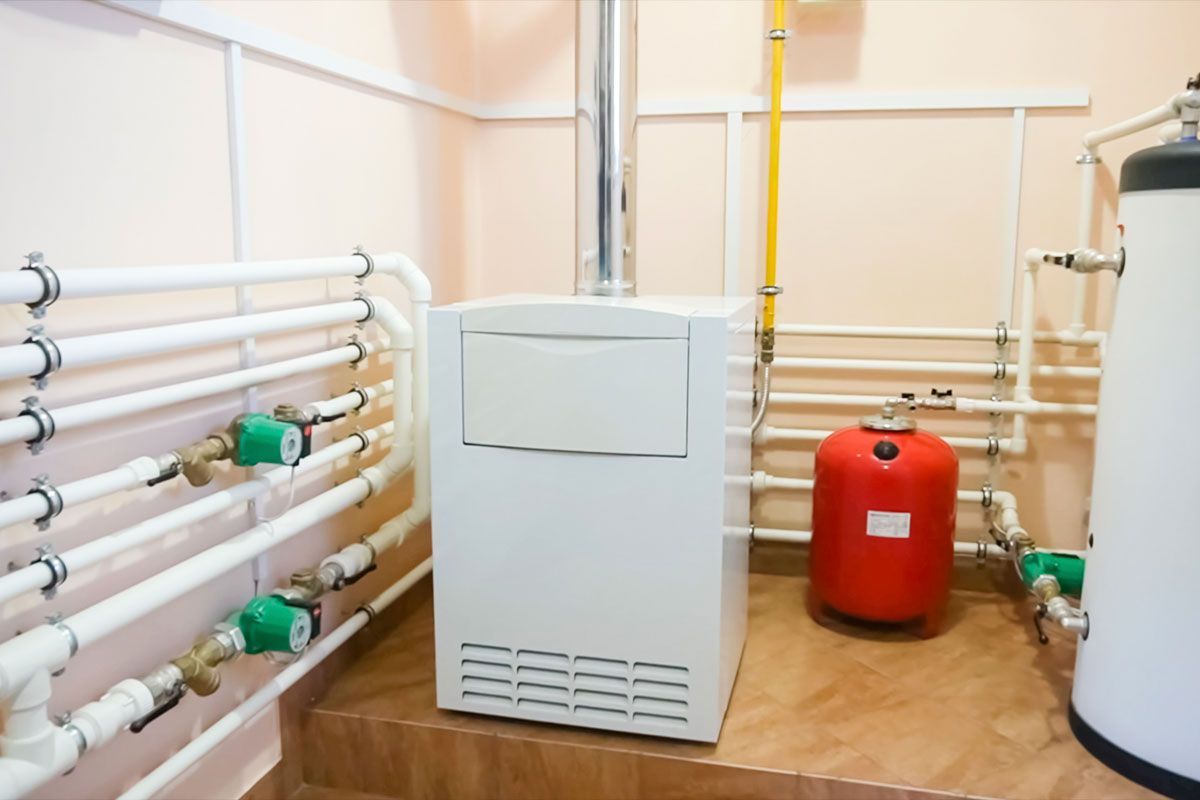 A room with a boiler and a water heater in it.
