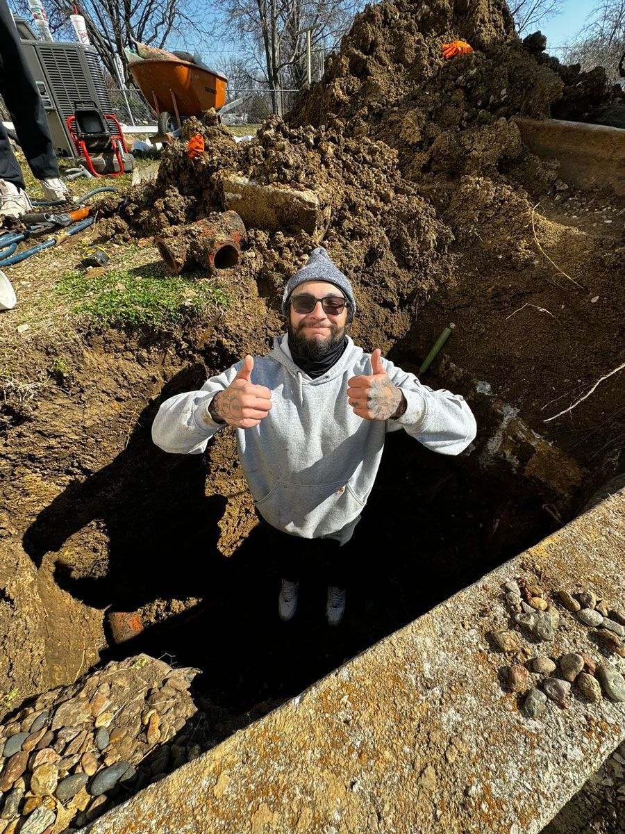 A man is giving a thumbs up while standing in a pile of dirt.