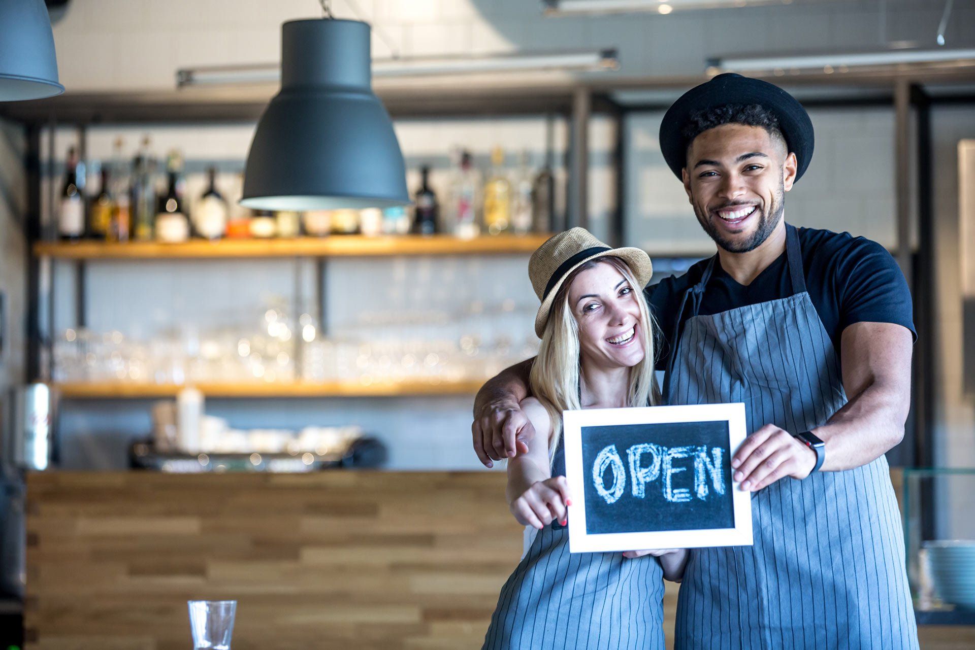 Man and woman holding small chalkboard — Waukegan, IL — Aapril Tax Service