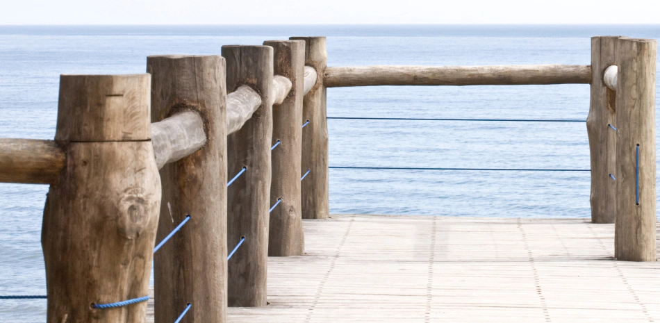 Wooden fence on a pier overlooking the ocean.