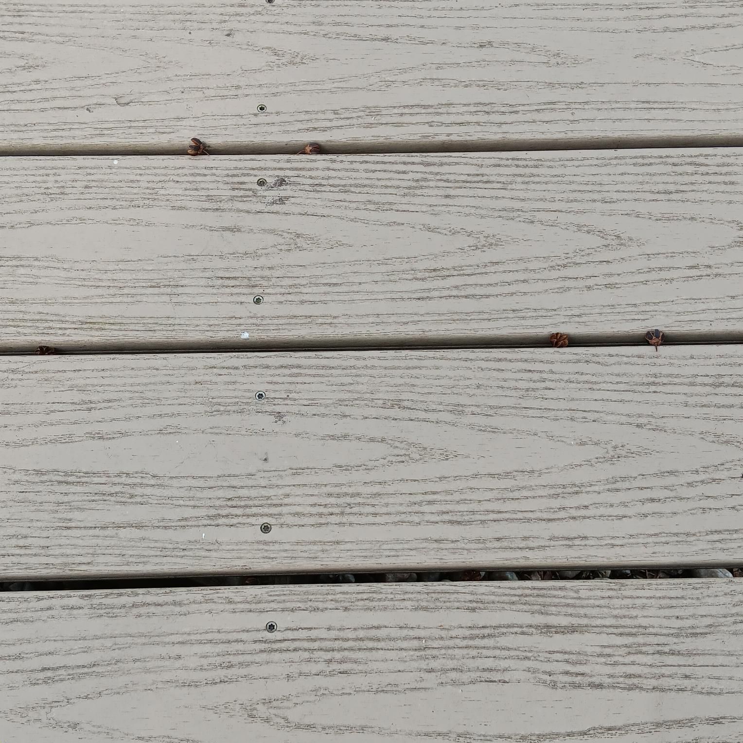 Gray-painted wooden deck boards with visible grain and small nails.