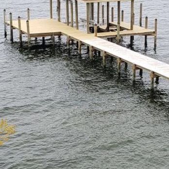 Wooden dock extending into water, with a covered area.