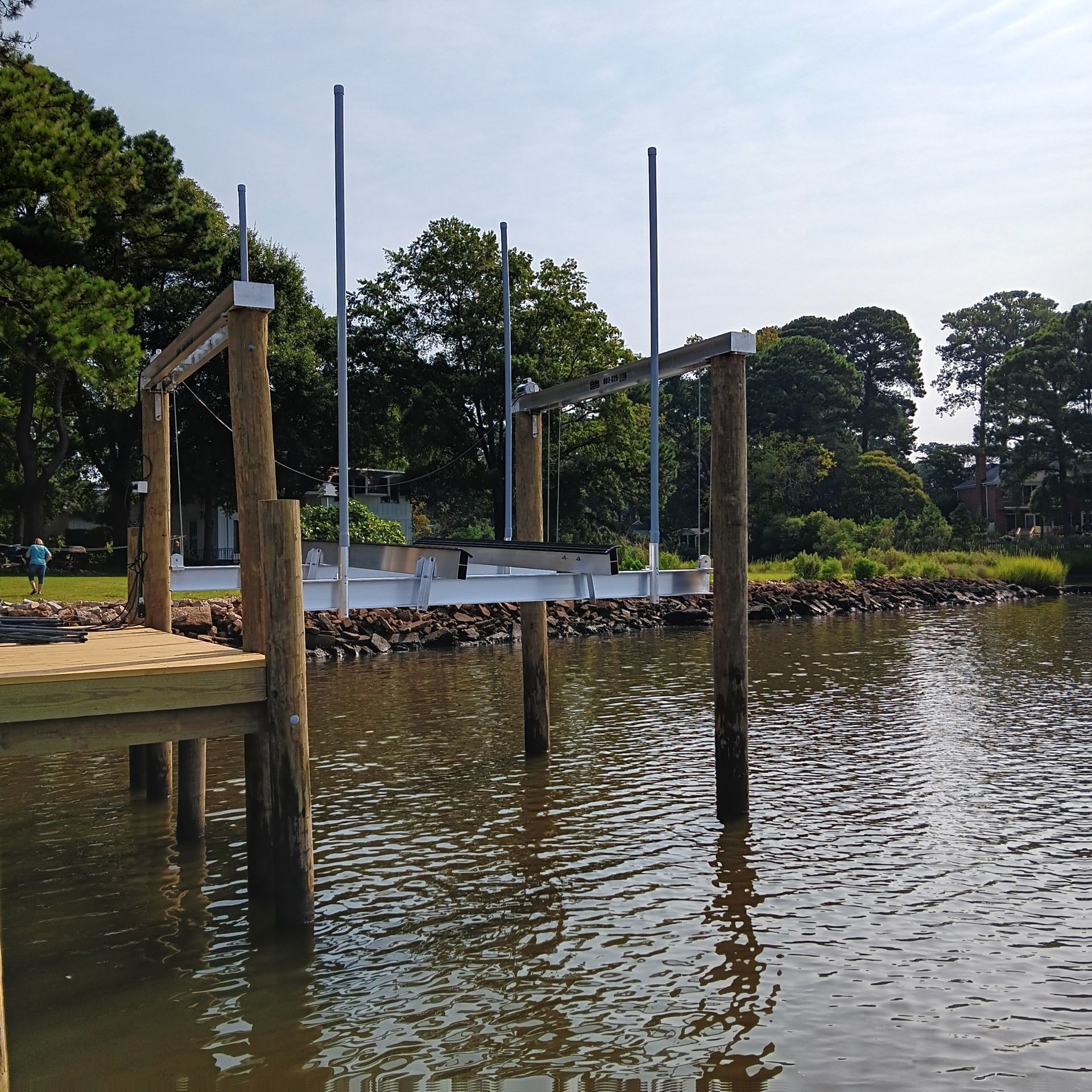 Boats docked on a lake, mountains in the background under a blue sky.