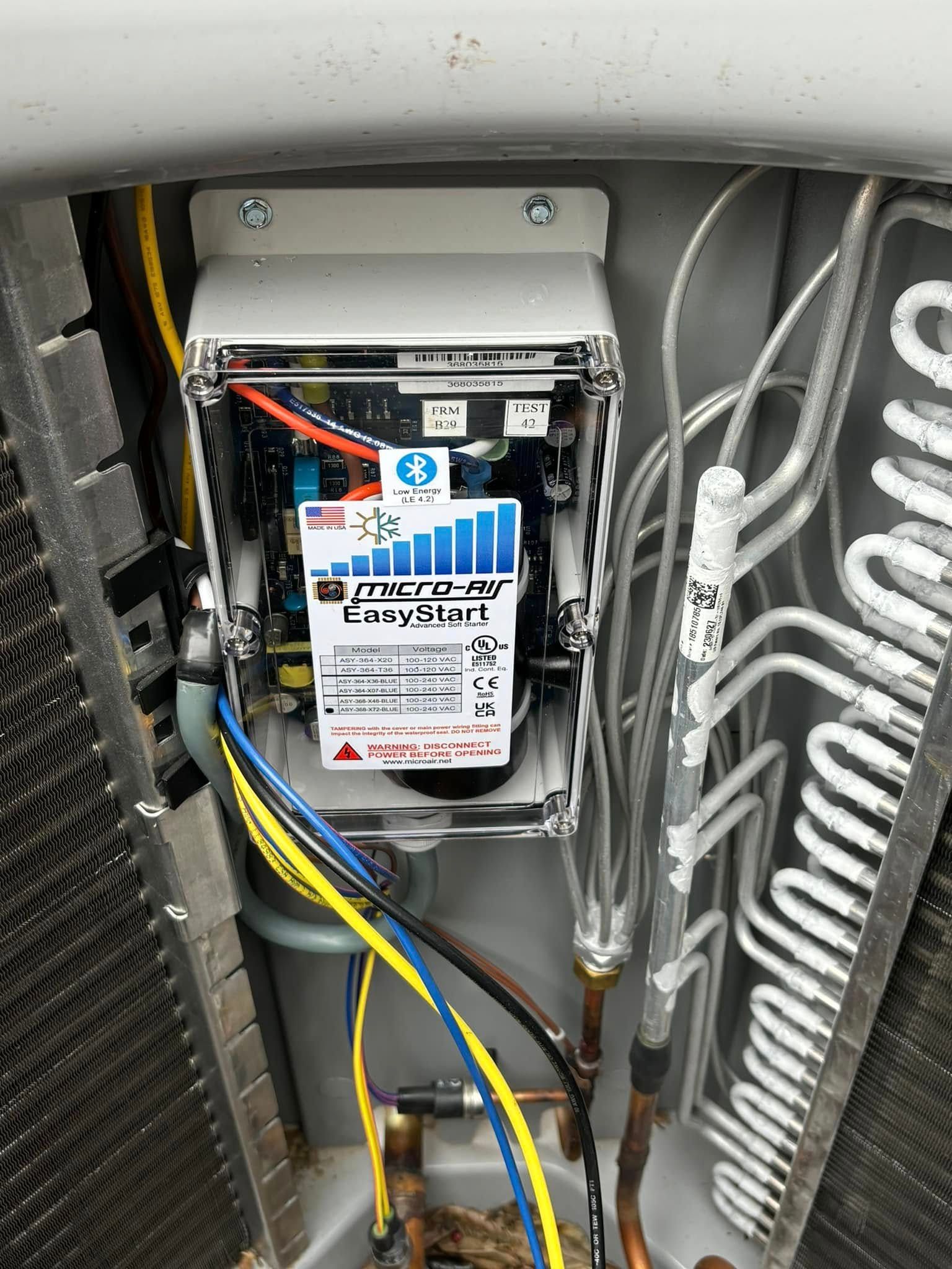 An open electrical control box for an HVAC unit, featuring a Micro-Air EasyStart soft starter module with visible wiring.