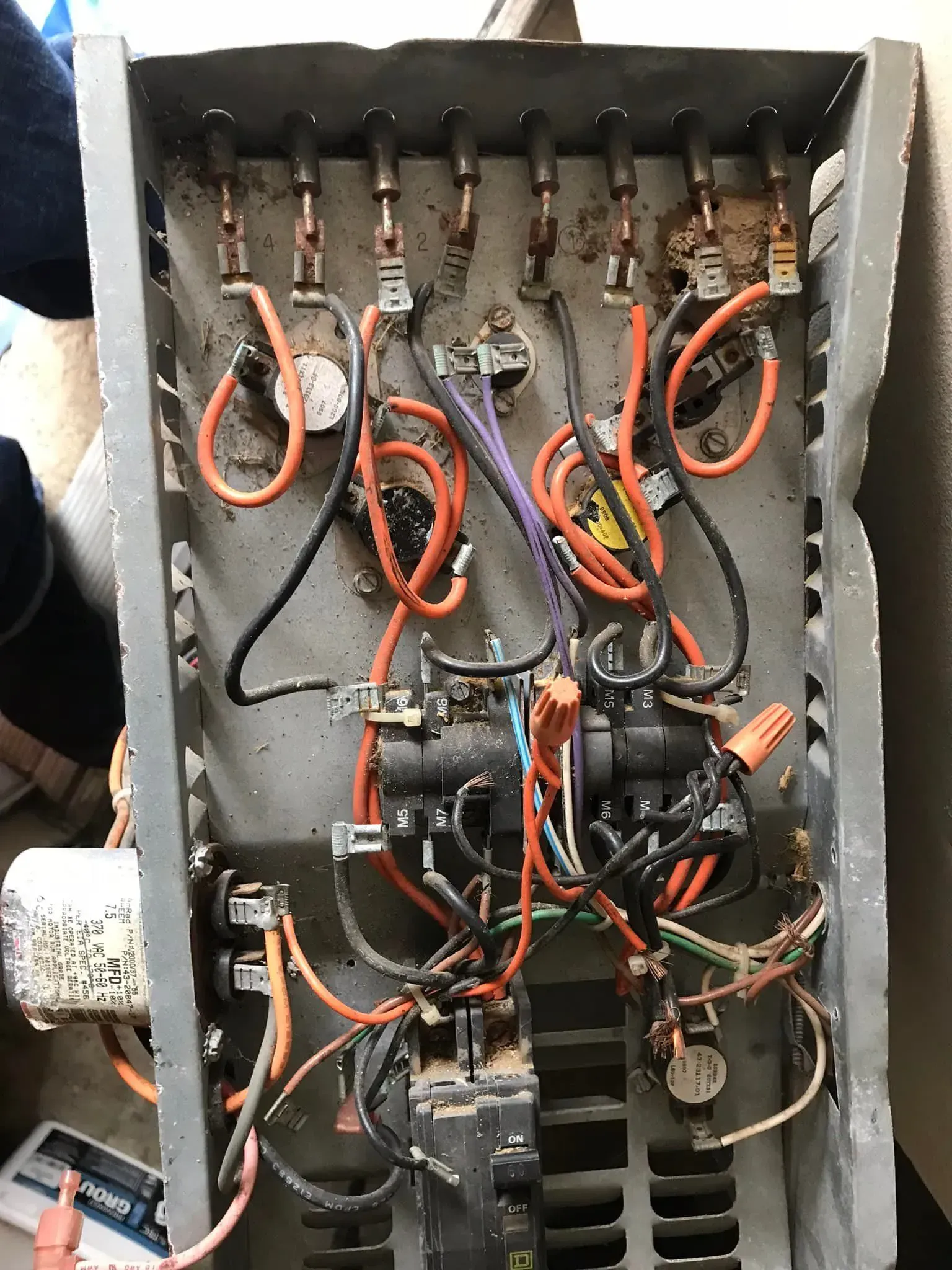Open electrical junction box showing orange and black wiring connected to various terminal points and a circuit breaker.