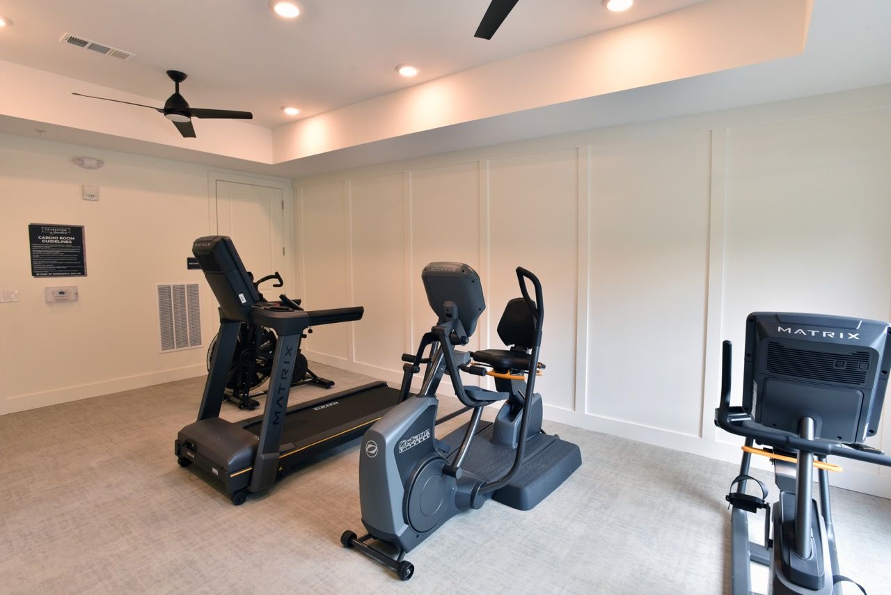 Small in-building fitness center with treadmill, stationary bike, and elliptical.
