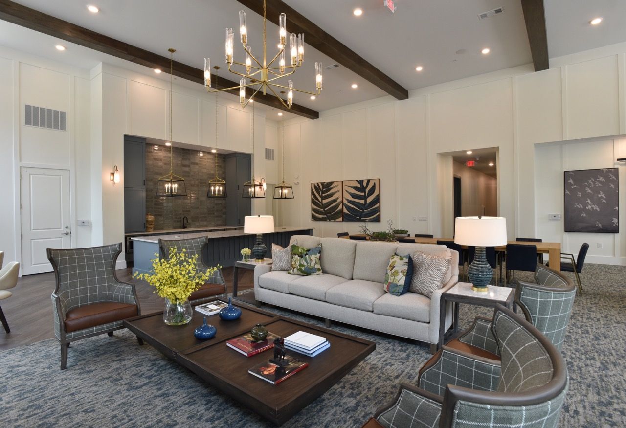 Open-concept resident lounge with white walls, modern furniture, and a kitchen island.